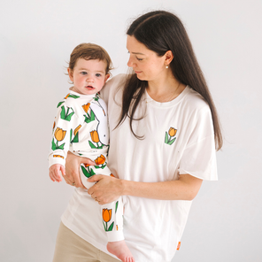 Donna che indossa la maglietta bianca per l'allattamento Miffy con un tulipano ricamato e cerniere per l'allattamento