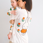 Mujer con la camiseta blanca de lactancia Miffy, con un tulipán bordado y cremalleras para la lactancia